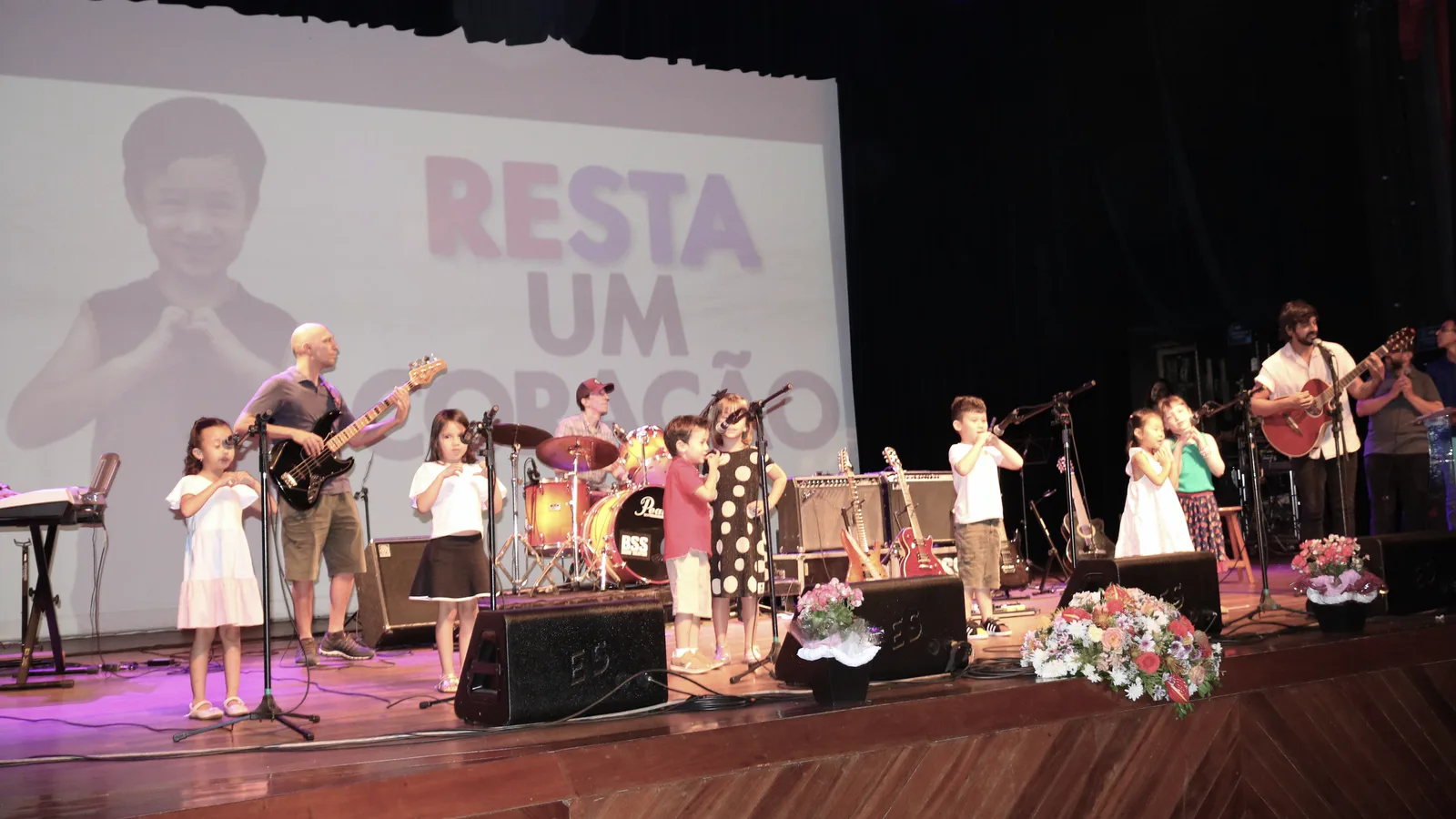 Alunos do Studio Musical tocando e cantando no palco, na apresentação anual da escola em Londrina