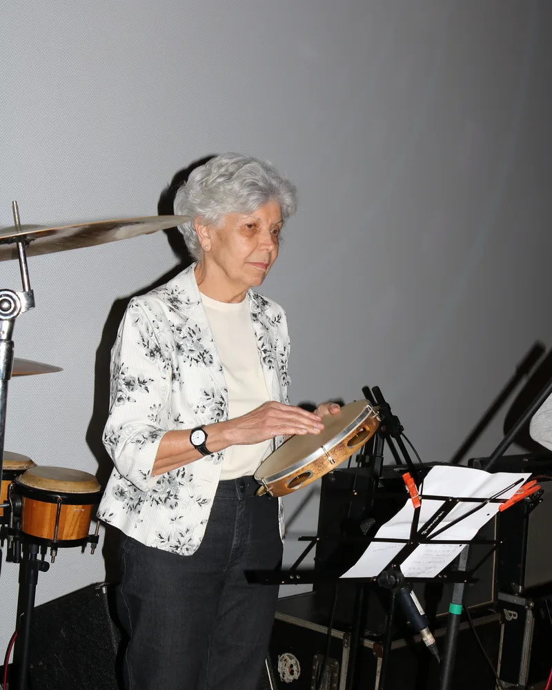 Aluna adulta do Studio Musical tocando pandeiro na vivência musical para adultos